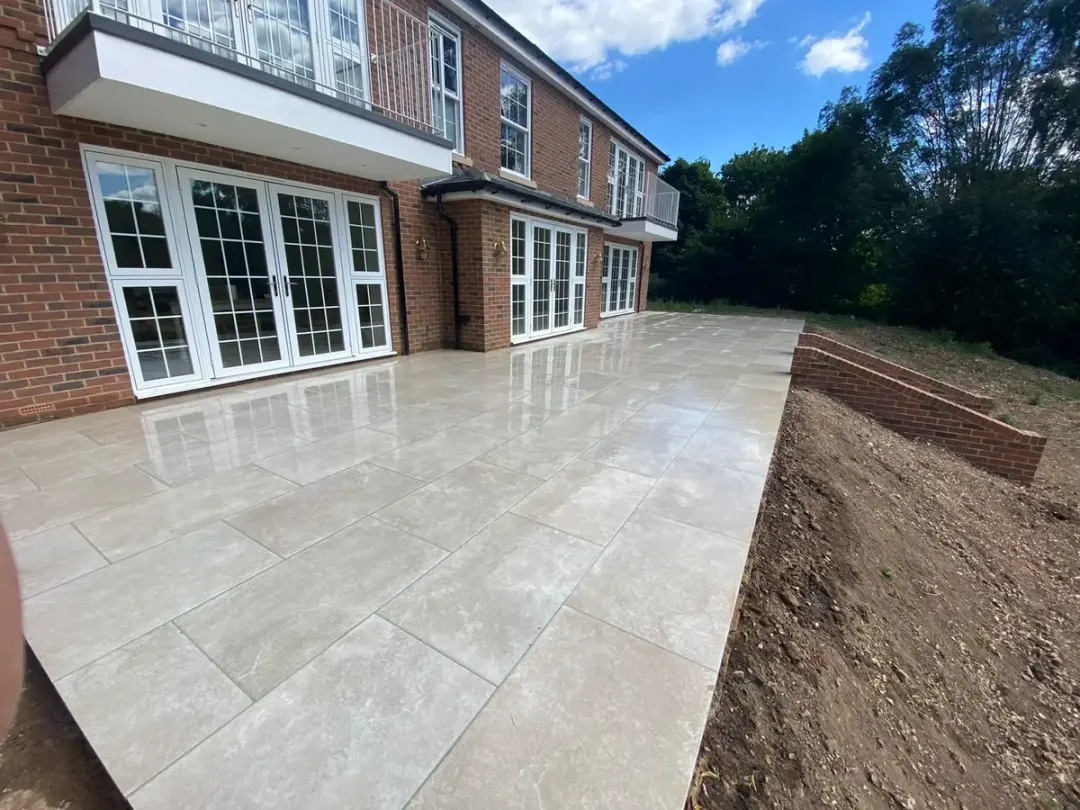 Long cream porcelain terrace along the back of a large new-build home
