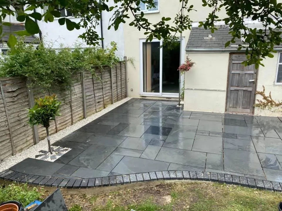 Dark slate patio with curved block edging and gravel border
